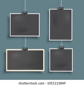 Set of realistic vector hanging photo frames  with paper clips on blue background.