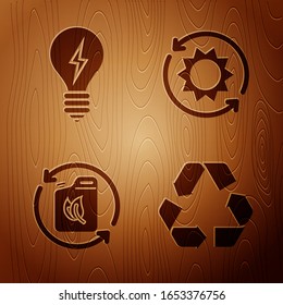 Set Recycle symbol, Light bulb with lightning symbol, Bio fuel canister and Solar energy panel on wooden background. Vector