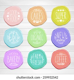 Set of retro badges on a wood background. Hand-drawn lettering and elements. Creative colored handmade food labels with inscriptions in vintage style.