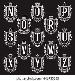 Set of royal coat of arms in medieval style. White vintage logos of letters from N to Z.