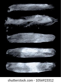 set of silver brushes on a black background