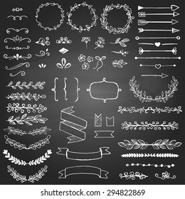 Set of sketched design elements on the blackboard. Arrows, floral elements, wreaths