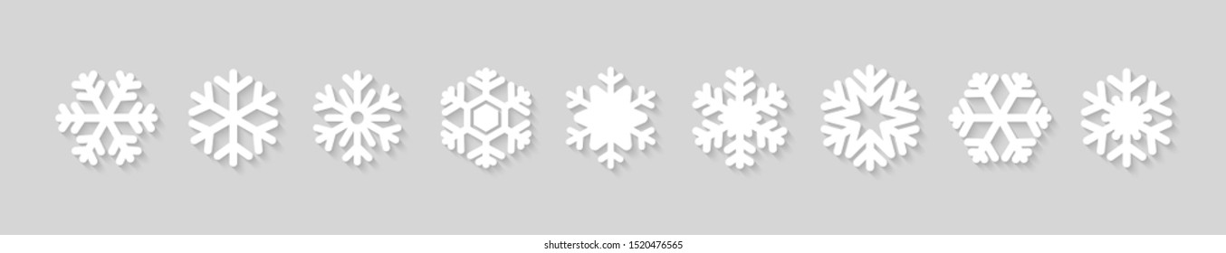 Set of snowflake icons with shadow on grey background. Vector Christmas and New Year decoration elements.