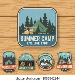 Set of Summer camp badges on the wood board. Vector. Concept for shirt , print, stamp, travel badges or tee. Design with rv trailer, camping tent, campfire, pot on the fire, axe and forest silhouette