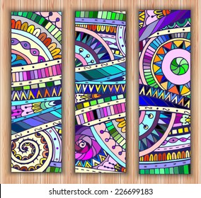 Set of three abstract doodle ethnic tribal hand drawn vector cards on wood background. Paisley batik background. Series of template frame design for card. Pattern with geometric mosaic elements.