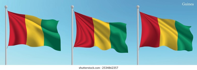 Set of three flags of Guinea waving on flagpoles with a vibrant blue sky backdrop.