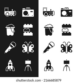 Set Toy building block bricks, Sand bucket, train, Photo camera, Microphone, Butterfly, Wood easel and Rocket ship toy icon. Vector