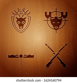 Set Two crossed shotguns, Deer head with antlers on shield, Trap hunting and Hunt on moose with crosshairs on wooden background. Vector