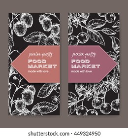 Set of two food market labels with fresh cherries and strawberries on black background. Includes hand drawn elements.