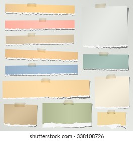 Set of various colorful torn note papers with adhesive tape on gray background