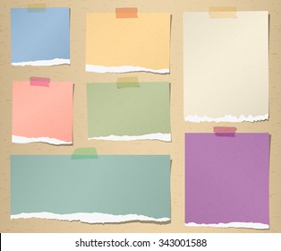 Set of various colorful torn note papers with adhesive tape on brown background