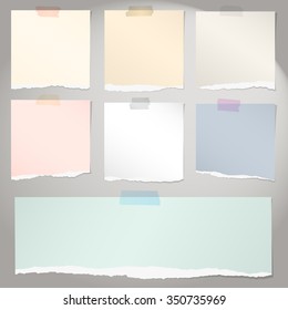 Conjunto de varios papeles de nota rasgados de colores con cinta adhesiva sobre fondo gris