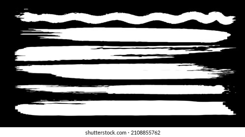 Un conjunto de pinceles vectoriales en forma de grunge. Pintura blanca pinta con un pincel seco sobre un fondo negro