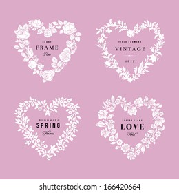 Set of vector floral frames in the shape of heart. Four White silhouettes of flowers on a pink background. Design elements.