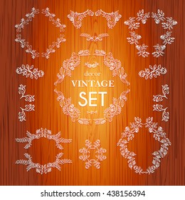 Set  vector hand drawn calligraphic element. The pattern frame of the branches of the roses. Wooden background.Pattern border Floral ornament of leaves and flowers.Vintage style.