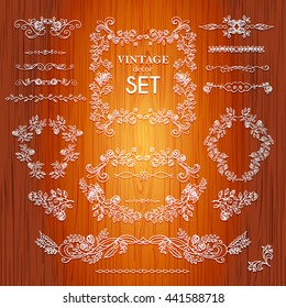 Set vector hand drawn calligraphic element. The pattern frame of the branches of the roses. Wooden background.Pattern border Floral ornament of leaves and flowers.Vintage style.