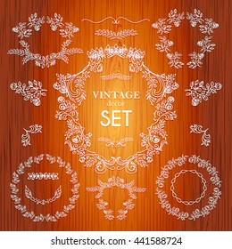 Set vector hand drawn calligraphic element. The pattern frame of the branches of the roses. Wooden background.Pattern border Floral ornament of leaves and flowers.Vintage style.