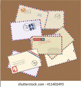 Set of vintage air mail envelopes with stamps, postal elements and copy space for text on wooden table. Minimal vector illustrator. 