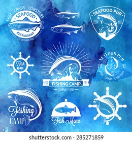 Set of vintage fish logos with helm, sunburst and salmons on watercolor background for your design