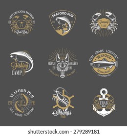 Set of vintage seafood logos with fish, crab, lobster, shrimp, anchor, helm and sunburst on gray background. White, gold and gray colors