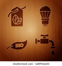 Set Water tap, Tag with leaf symbol, Leaf Bio symbol and LED light bulb on wooden background. Vector