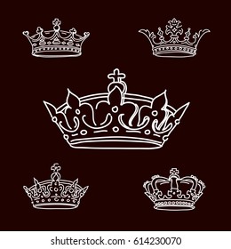 Set white crowns on black background. Vector Icons.