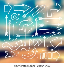 Set of white doodle sketch arrows on blurred background with seashore. Vector illustration.