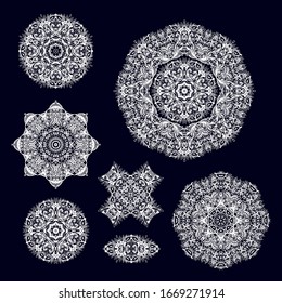 Set of white ornamental decorative rosette, snowflakes, mandalas on dark background