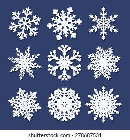 Set of  white paper snowflakes isolated on blue background. Vector illustration.