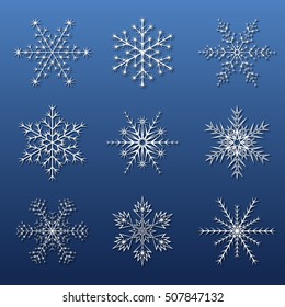 set of white snowflakes with shadow on a blue background