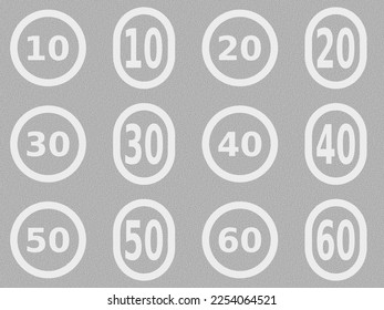 A set of white vector graphic speed limits which are painted on to the surface of the road