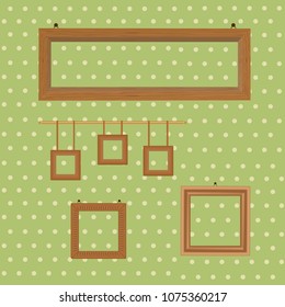 Set of wooden decorated frames hanging on the background of wallpaper in polka dots