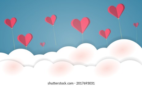 Several red paper hearts tied with strings floated above the white clouds and blue sky.