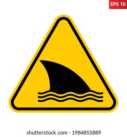 Shark warning sign. Vector illustration of yellow triangle sign with shark fin icon inside. Caution dangerous fish. Symbol used in beach. Entering the water is hazardous. Dangerous sea creature.