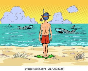 sharks in the water, a man in a scuba mask is preparing to dive, standing on the seashore of the ocean