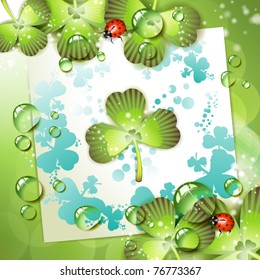 Sheet of paper and clover over springtime background