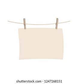 A sheet of paper is dried on a clothesline.