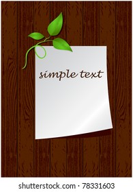 Sheet of paper with green shoots placed on wooden boards