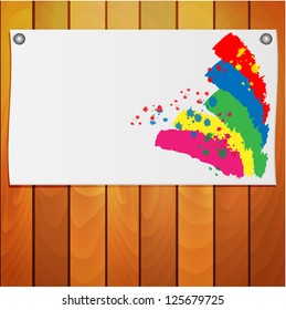 sheet of paper with the spots of paint on a wooden wall
