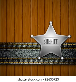 Sheriff's badge with denim element on a wooden background.