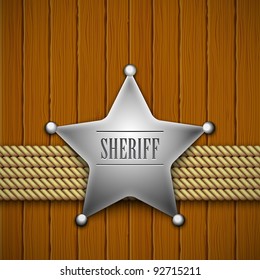 Sheriff's badge on a wooden background.