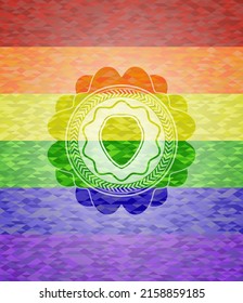 icono del escudo sobre fondo de mosaico con los colores de la bandera LGBT. 