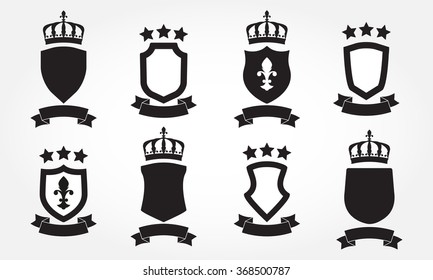 Shield icon set. Shields with ribbon with ribbon, crown and stars. Heraldic royal design. Retro style blazon, badge or label set. Vector illustration.