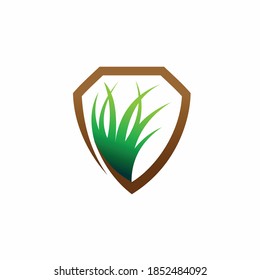 shield logo with green grass