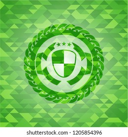 shield, safety icon inside green emblem with triangle mosaic background