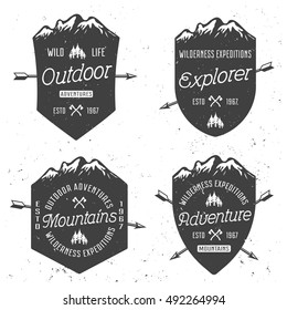 Shields with mountains set of four vector vintage badges, emblems, labels or logos with sample text for your design and grunge texture isolated on white background