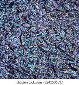 Shining crumpled foil illuminated in turquoise, yellow, blue, pink and purple