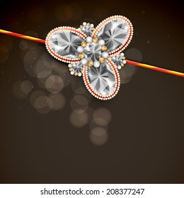 Shiny diamonds decorated rakhi on brown background for Hindu community festival Raksha Bandhan celebrations. 