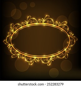 Shiny golden floral decorated frame in oval shape on brown background.
