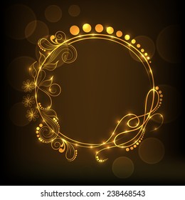 Shiny golden frame decorated by beautiful floral design on brown background.